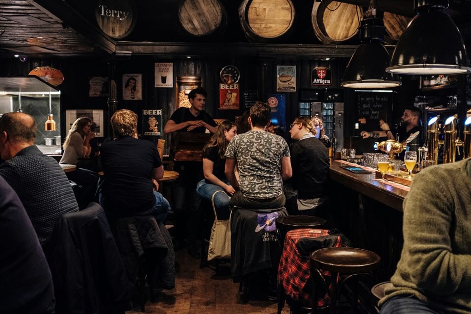 A busy bar with customers and beer taps